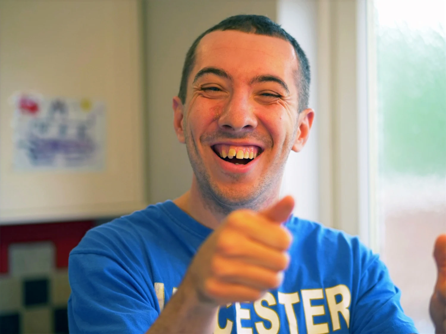 A man laughing and giving a thumbs-up